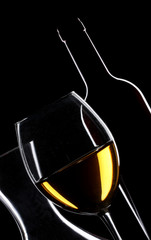 White wine bottle and glass silhouette over black background