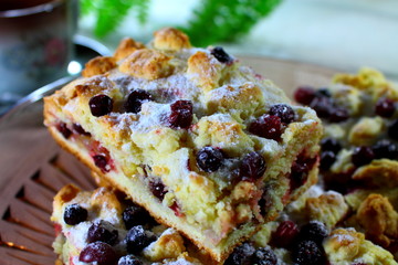 Some pieces of cranberry pie on the plate with a cup