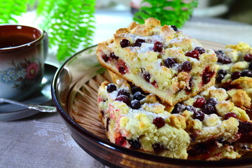 Some pieces of cranberry pie on the plate with a cup