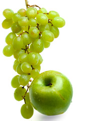 Cluster of grapes in water drops and apple..