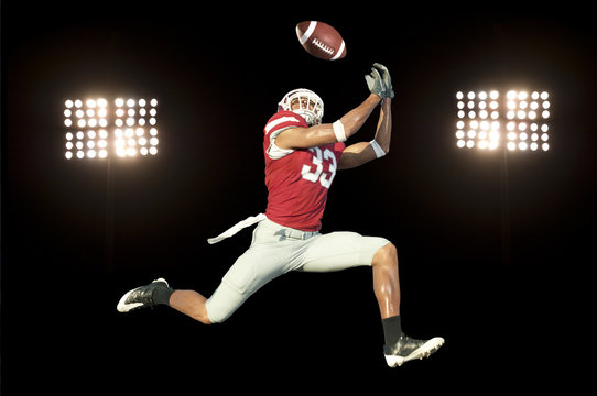 football player catches ball in midair