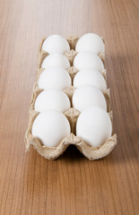 Many white eggs on the wooden table