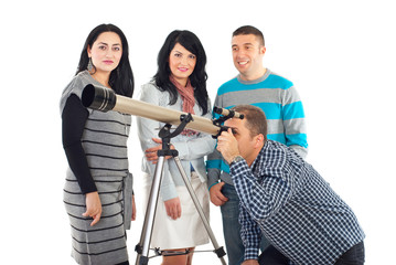 Four friends having fun with telescope