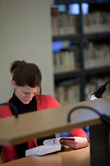 pretty female college student in a college library (shallow DOF;