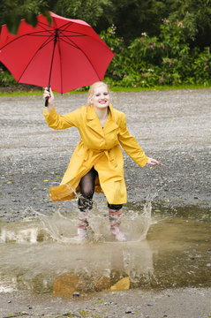 Hübsche junge Frau springt im Regen