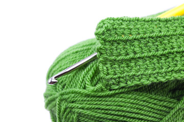 Skein of wool, crochet hook  and knitted piece isolated on white