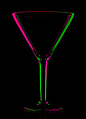 transparent colored empty martini glass on black