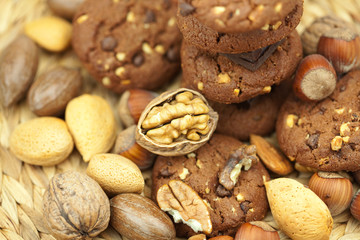 oatmeal cookies, chocolate and nuts on a wicker mat