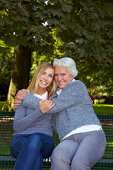 Oma umarmt Enkelin im Park