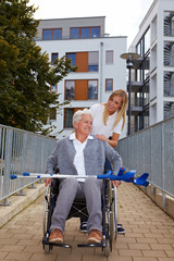 Rollstuhlfahrerin mit Begleitung auf Rampe