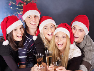 Group young people in santa hat drinking champagne.