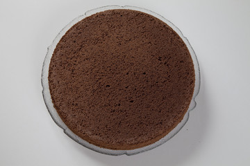 Dunkler Tortenboden auf einem Glasteller