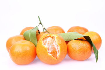 Mandarin oranges one partially peeled, on white background
