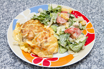 chicken breast baked under cheese with salad