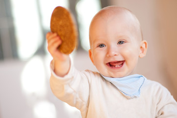 Fröhliches Baby mit ersten Zähnchen und Keks