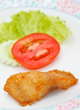 Piece of fried fish and vegetables
