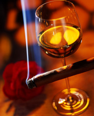 glass of wine with a cigar in a red ambience