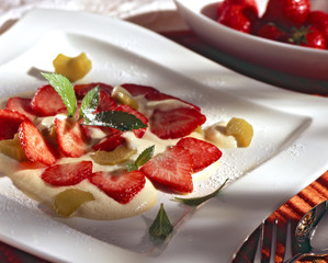 rhubarb foam with strawberry on a white plate.