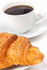Breakfast: coffee and croissant with sesame seeds