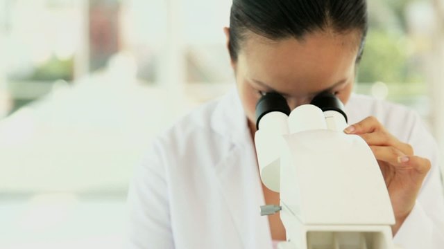Female Researcher at a Microscope