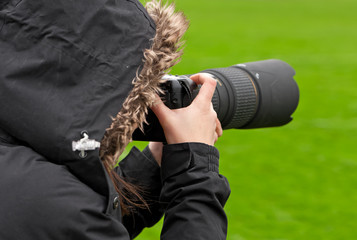 Photographer shooting with camera and big tele lens