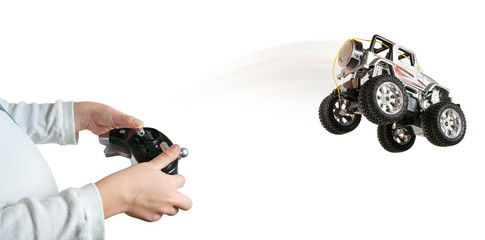 Little boy with remote control makes toy car to jump