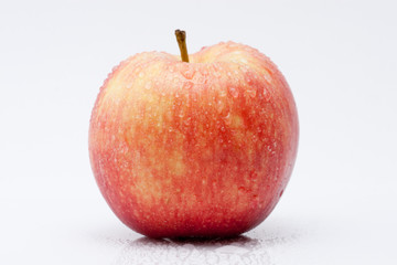 Apfel mit Wassertropfen vor weissem Hintergrund