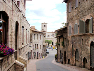 Medieval street in Assisi, Italy and the church San Pietro