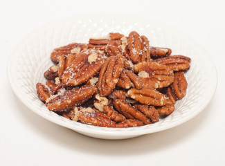 Sugared toasted pecans in a white china bowl with clipping path