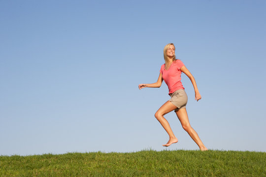 Young Woman Running Through Field