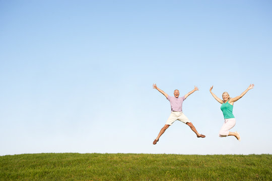 Senior Couple Jumping In Air