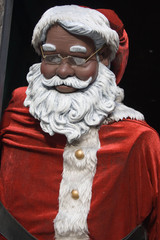 Black Santa Claus with glasses looks out the window