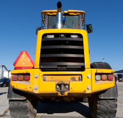 Yellowv tractor with triangle sign on-board