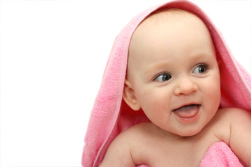 Smiling little baby wrapped in a pink towel on white background