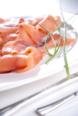 Lachs mit Schnittlauch serviert auf weißem Tisch