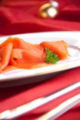 geräucherter Lachs zu Weihnachten auf rot dekoriertem Tisch