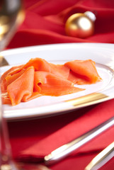 geräucherter Lachs zu Weihnachten auf rot dekoriertem Tisch