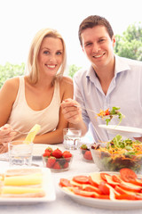 Young couple eating outdoors