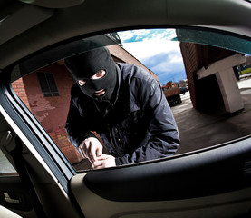 robber and the thief in a mask hijacks the car