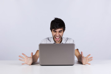 Young man shouting to a laptop