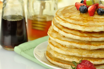 pancakes with maple syrup,honey and berries close up