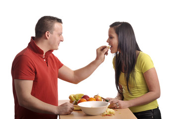 Obraz na płótnie Canvas young couple preparing a fruit salad