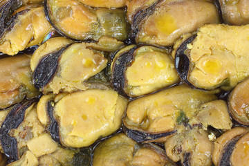 Close view of several small smoked mussels.