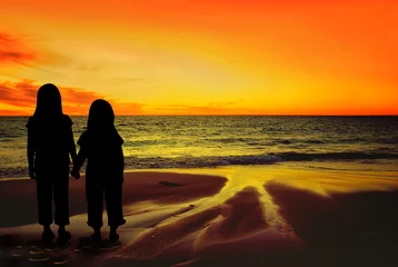 Fotobehang Silhouettes of Children on a sunset beach © Imagevixen