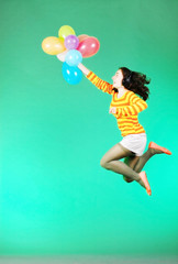 Fototapeta na wymiar Jumping happy girl with balloons