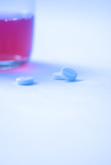 three tablets against the glass with liquid