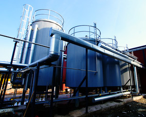 Industrial zone, Steel pipelines, tanks and valves against blue