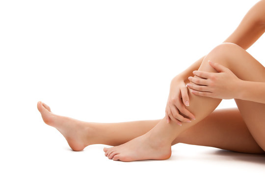Woman massaging legs sitting on white background