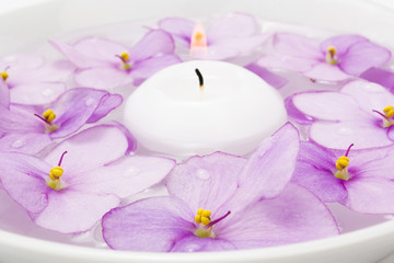 Fototapeta na wymiar Floating candle and lilac flower
