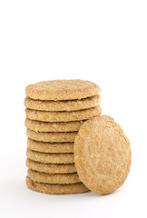 Pile of oaty cookies with one leaning against isolated on white